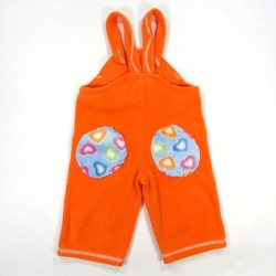 Salopette bébé fille de dos en polaire orange avec 2 gros patchs bleu ciel et petits coeurs colorés sur les fesses